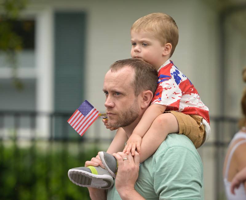 Former Wheaton resident Andy Larkin and his son Jacob, 2 watch the annual Wheaton Independence Day Parade on Thursday, July 4, 2024.
