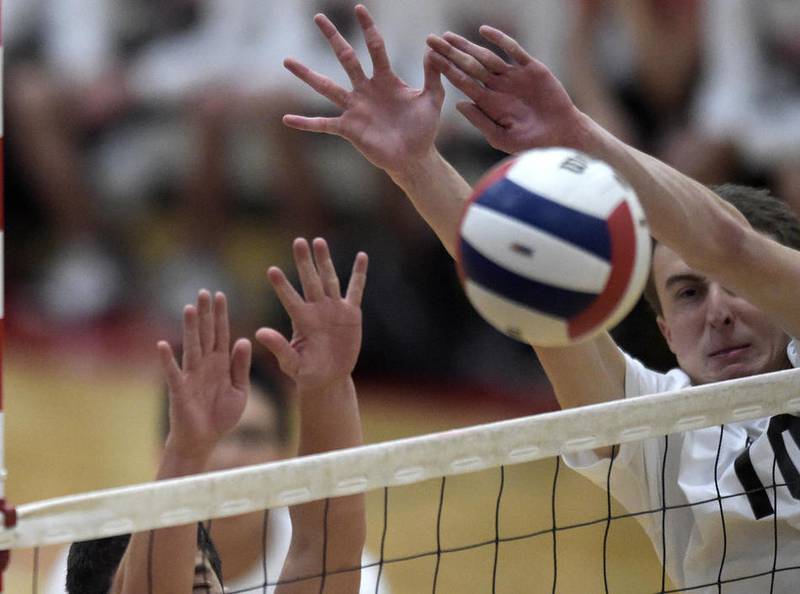 Huntley senior Luke Mahnke (right) and Juan Collazo block the ball Monday, May 1, 2017, during a home match against Harlem. Huntley in three sets.