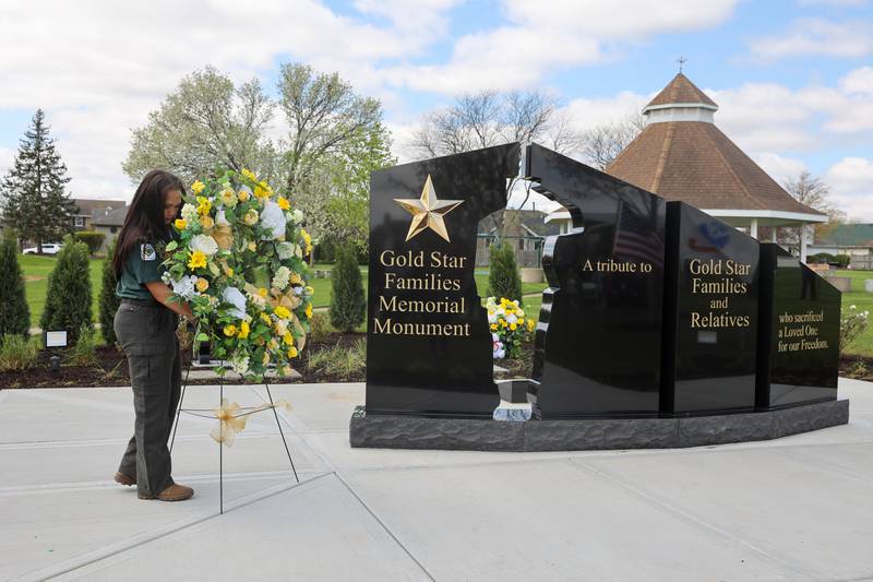 Alexis McCullough, 17, of Bourbonnais, places a wreath next to the new Gold Star Families Memorial Monument, which she successfully completed for her Eagle Scout project, during the dedication ceremony at Marcotte Park in Bourbonnais on Saturday, April 26, 2025.