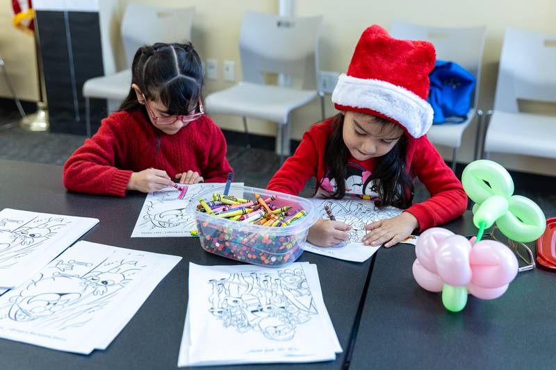 Catalina and Camila Acosta, of Lockport, color holiday-themed sheets at the White Oak Library District’s Lockport Branch during Lockport’s Christmas in the Square festivities on Nov. 29, 2025.