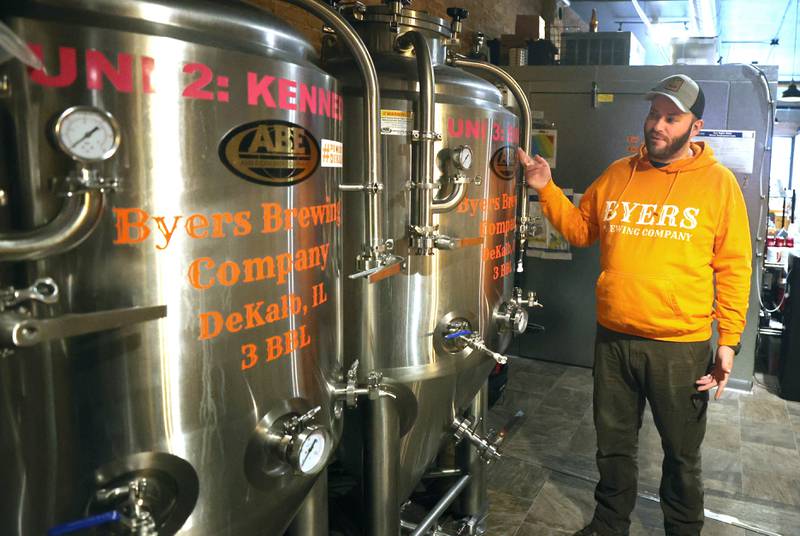 Steve Byers, co-owner of Byers Brewing Company, explains that each of the three tanks are named after one of his daughters as he talks about the brewing process Friday, Jan. 6, 2023, in the production area at the brewery and taproom in DeKalb. Byers is planning an expansion of its operations to include another location,  216 N. Sixth St., in DeKalb for production only.