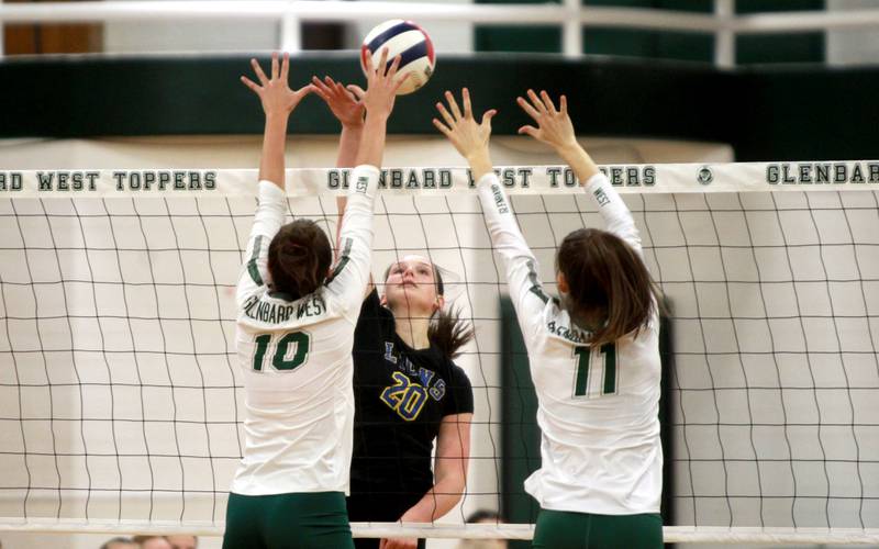 Lyons Township’s Grace Turner (center) goes up for a kill during a game at Glenbard West in Glen Ellyn on Tuesday, Oct. 10, 2023.