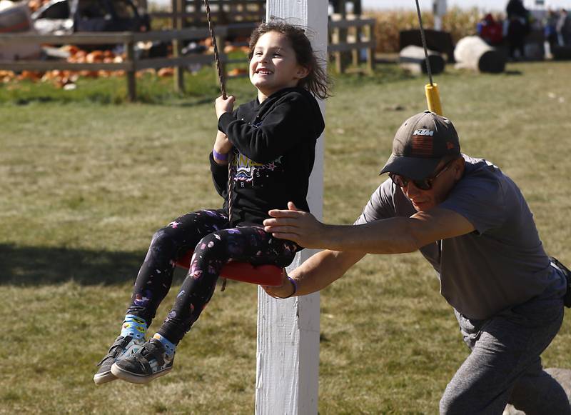 Vladimir Lyskov, of Chicago, push his granddaughter Nina, 4, as she rides a zip line Monday, Oct. 10, 2022, at Richardson Adventure Farm, 909 English Prairie Road in Spring Grove. The farm's main attraction is a James Bond-themed corn maze, but it also features a 50-foot observation tower, train rides, a carousel, picnic areas, wagon rides, a zip line, 150- and 100-foot slides, zorbing, a petting zoo, pumpkin patch, goat feeding area, pedal kart tracks, live music on weekends, a kid's play area, jumping pillows, pig races, air cannons, a paintball shooting gallery, indoor restrooms, gift shop and wine tasting bar.