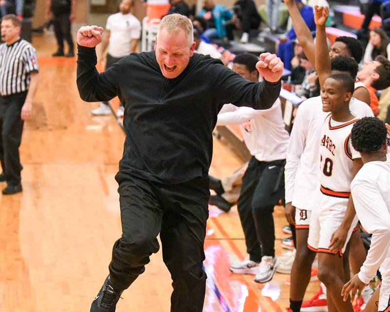 DeKalb's head coach Mike Reynolds jumps for joy after a basket was made during the fourth quarter of the championship game of the Dayton Classic tournament while taking on Phillips High School held at DeKalb High School on Saturday Dec. 30, 2023.