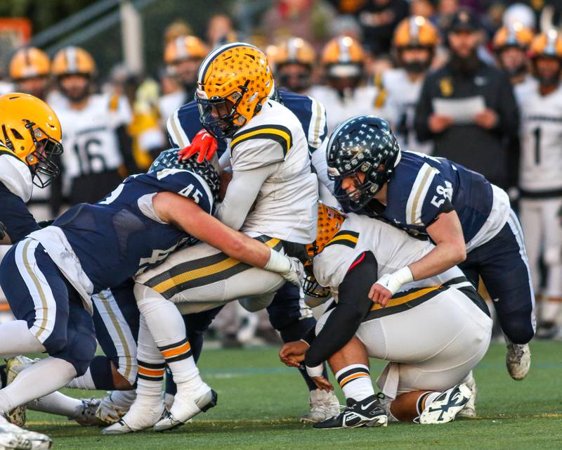 St Laurence's Aaron Ball (6) is tackled by IC Catholic Prep's Foley Calcagno (45) during Class 4A third round playoff football game between St Laurence at IC Catholic Prep.  Nov 11, 2023.