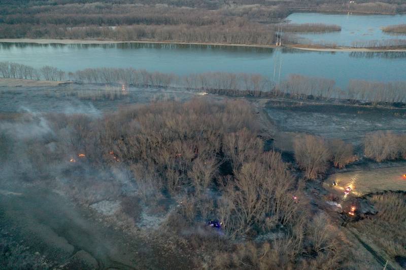 Fire departments work the scene of a large brush fire near the 12000 block of West Bottom Road on Monday, March 2, 2025 near Granville. The fire was elevated to the second alarm as the flames spread further west. Over 150 acres of timber burned along the Illinois River during the incident.