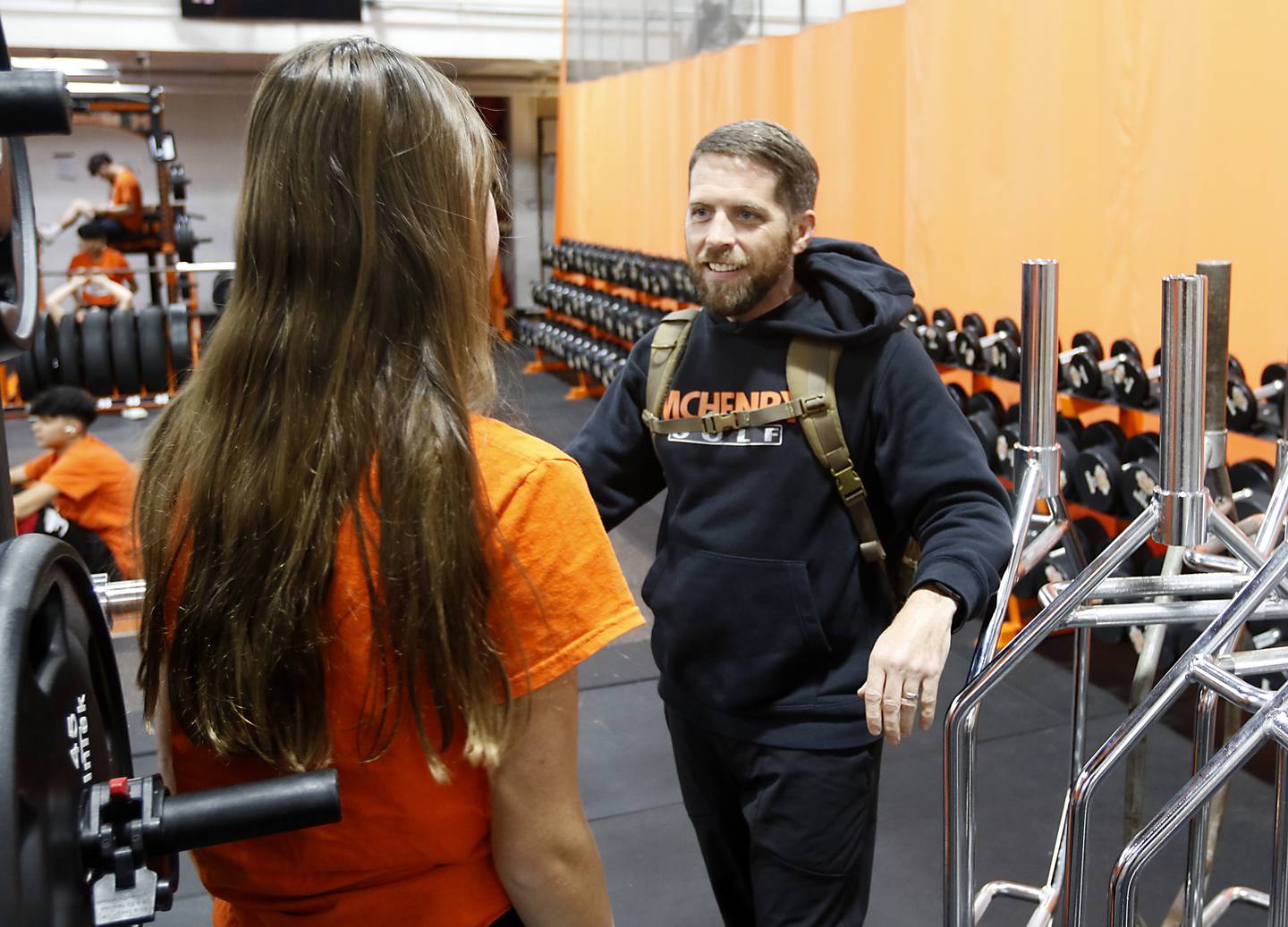 McHenry High School teacher, U.S. Army veteran, and golf coach Ray Hagerty talks with golfer Kilynn Axelson inside the weight room at school on Tuesday, Oct. 31, 2023.