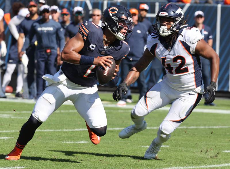 Chicago Bears quarterback Justin Fields scrambles away from Denver Broncos linebacker Nik Bonitto to throw a touchdown pass during their game Sunday, Oct. 1, 2023, at Soldier Field in Chicago.