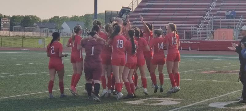 The Huntley girls soccer team celebrates with the championship plaque from the Class 3A Huntley Regional after beating DeKalb 5-0 on Friday, May 19, 2023.