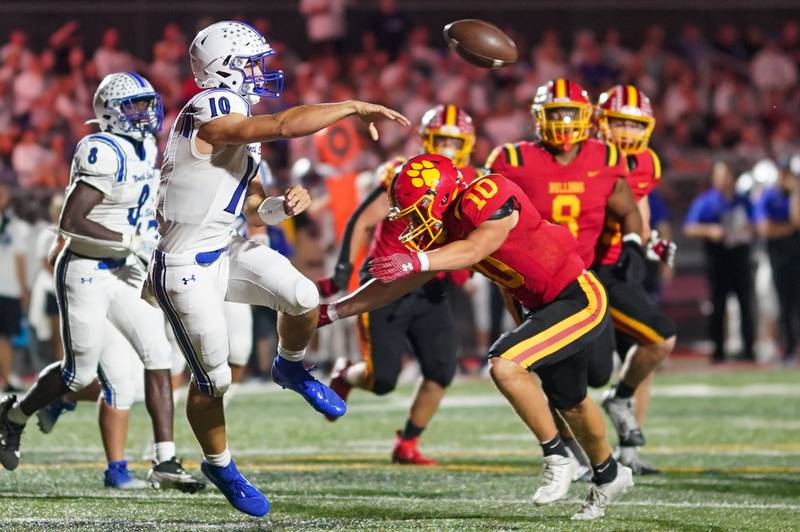 St. Charles North's Ethan Plumb (left) throws a pass while pressured by Batavia’s Jacob Jansey (right) during a football game at Batavia High School on Friday, Sep 20, 2024.