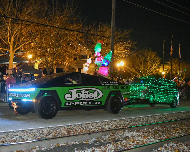 A blowup grinch catches a ride on U-Pull-It float during the parade on Friday Nov. 21, 2025, that kicked off the tree lighting ceremony held at Riverfront Park in Yorkville.