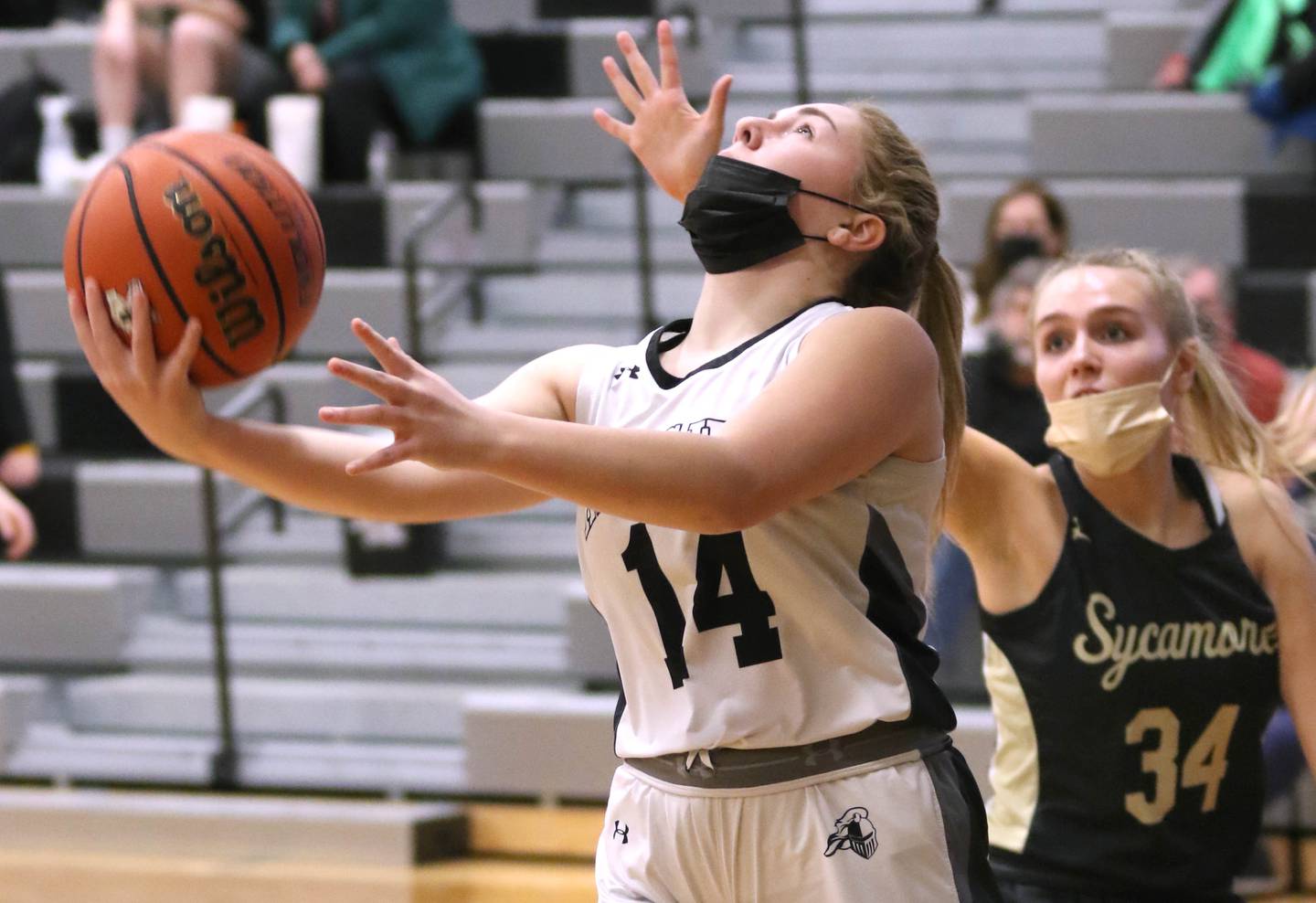 Kaneland's McKenzie Schueler attempts a reverse layup as Sycamore's Reese Hill defends during their game Tuesday, Feb. 1, 2022, at Kaneland High School in Maple Park.
