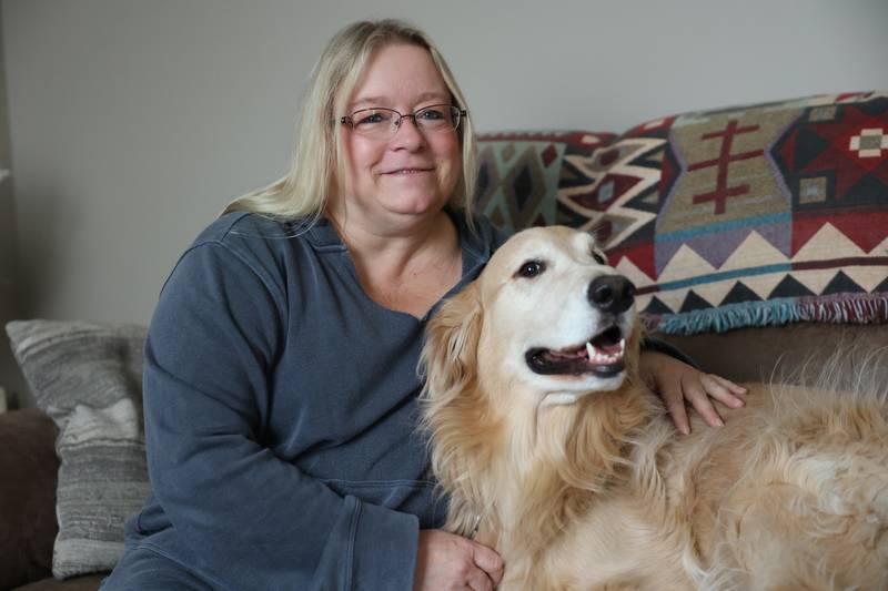 Kathy Vanoskey sits with Teddy, 4, on the couch in her Minooka home. Vanoskey is raising money to pay for Teddy's surgery, a repair of the canine version of a torn ACL.