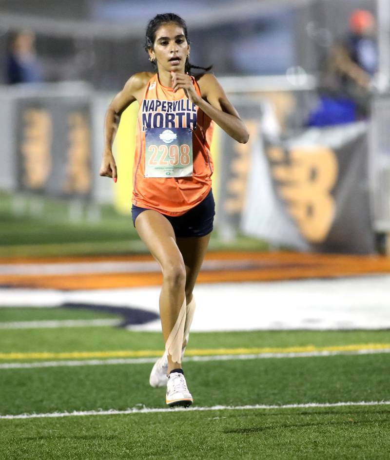 Naperville North’s Rianna Tandon comes to the finish of the varsity girls race during the Naperville North Twilight Cross Country Invitational on Wednesday, Oct. 9, 2024 in Naperville.