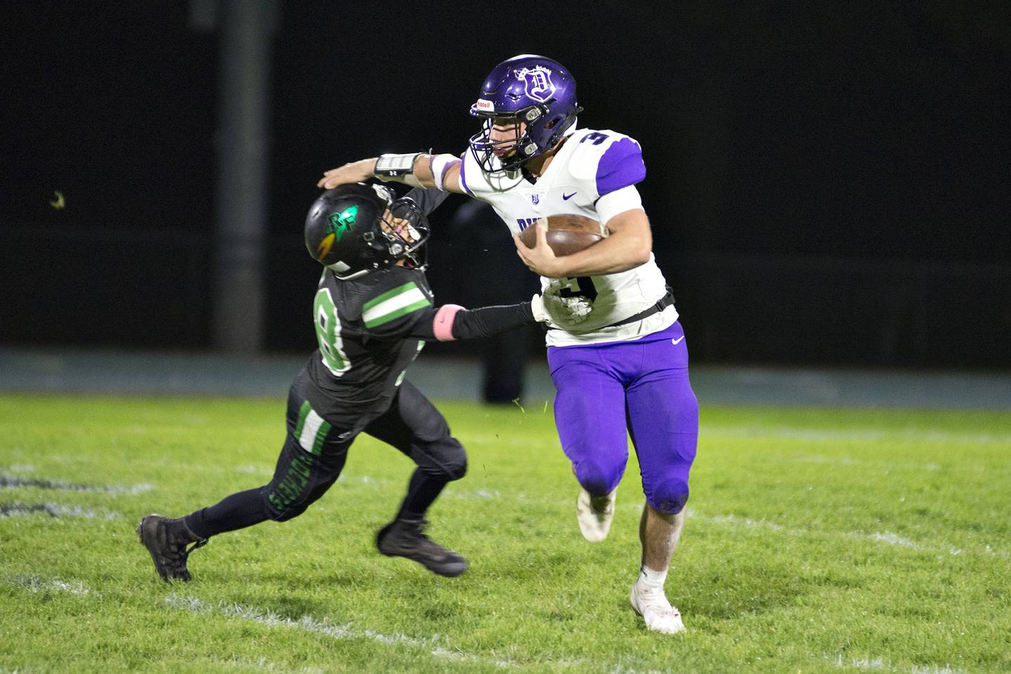 Dixon's Rylan Ramsdell stiff arms Rock Falls' Michael Flowers Friday Oct. 22, 2021.