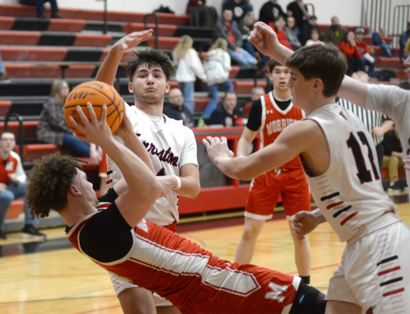 Morrison's Dawson Hepner (1) tries to pass the ball as he falls backwards as Foreston's Mickey Probst and Darin Greenfield defend during a Saturday, Feb. 8, 2025 game at Forreston High School.