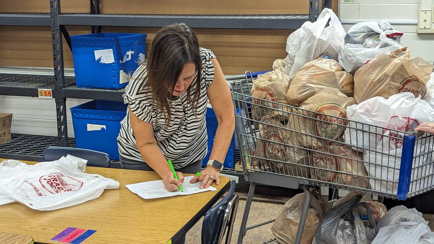 Bags of Hope board member Allison Suchinksi updates a donation list on Wednesday, October 4, 2023, at Plainfield Academy. Bags of Hope is a Plainfield-based nonprofit that feeds hundreds of Will County students each weekend through a donation-funded backpack program.