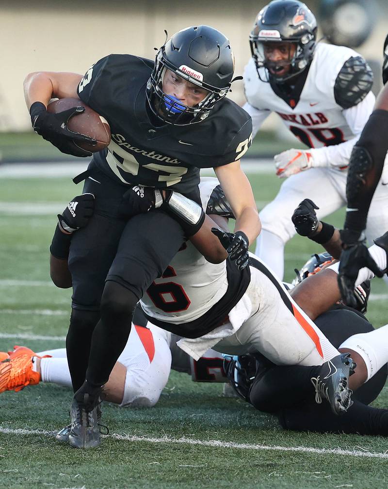 Sycamore's Dylan Hodges tries to pull away from DeKalb's Travis Moore during the First National Challenge game Friday, Aug. 25, 2023, in Huskie Stadium at Northern Illinois University in DeKalb.