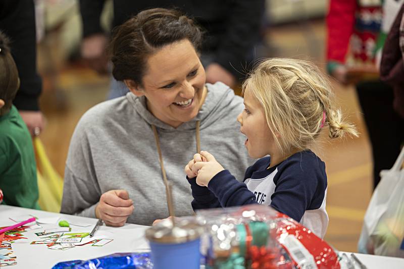 Liz Krafft and daughter Charlotte, 4, laugh and smile while helping wrap gifts Saturday, Dec. 9, 2023 at Tampico’s Christmas in the Country event. Charlotte went on a shopping spree with mom picking out gifts for loved ones including her babysitter, pooch, dad, brothers and grandma and grandpas kitty.