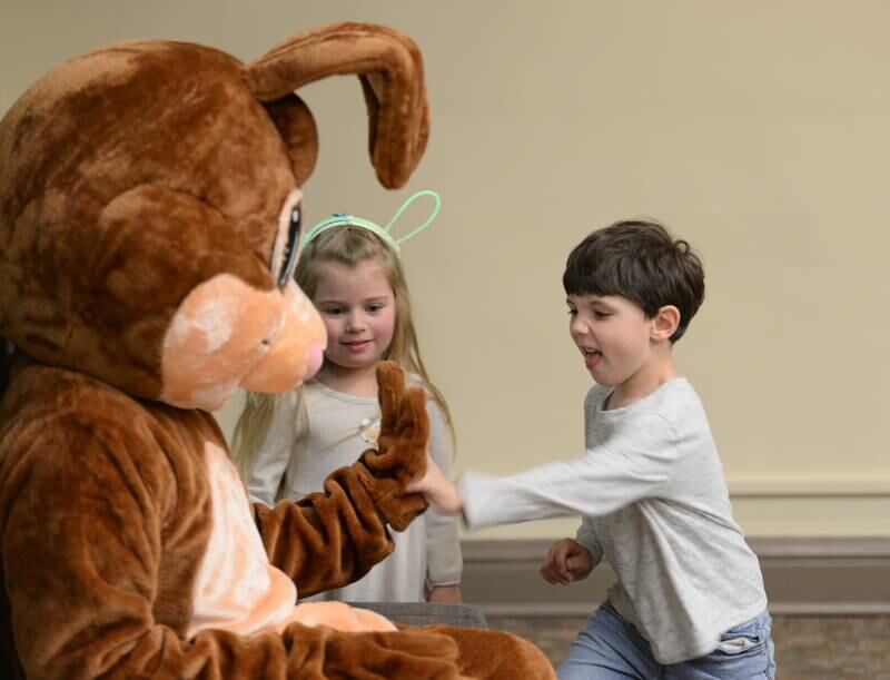 Children including (left) Audrey Wienkes and Cameron Homan of Downers Grove say hello to the Easter Bunny  during the Downers Grove Bunny Hop Egg Hunt Friday, March 22, 2024.