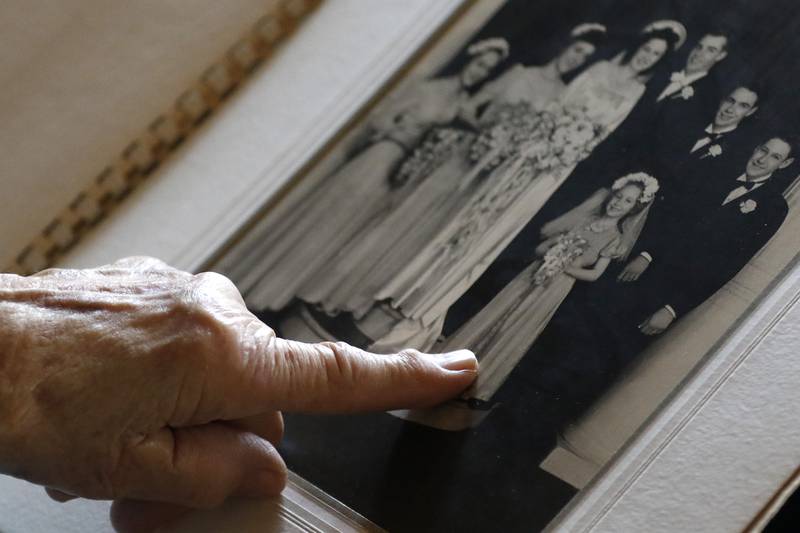 Rosemarie Lesmeister, 93, shows her siblings included in her wedding party as she flips through a wedding book from 1947 on Friday, April 9, 2021, with her husband, Lloyd, at their home in Crystal Lake.  The couple got married at 19 and will be celebrating their 74th anniversary this year.