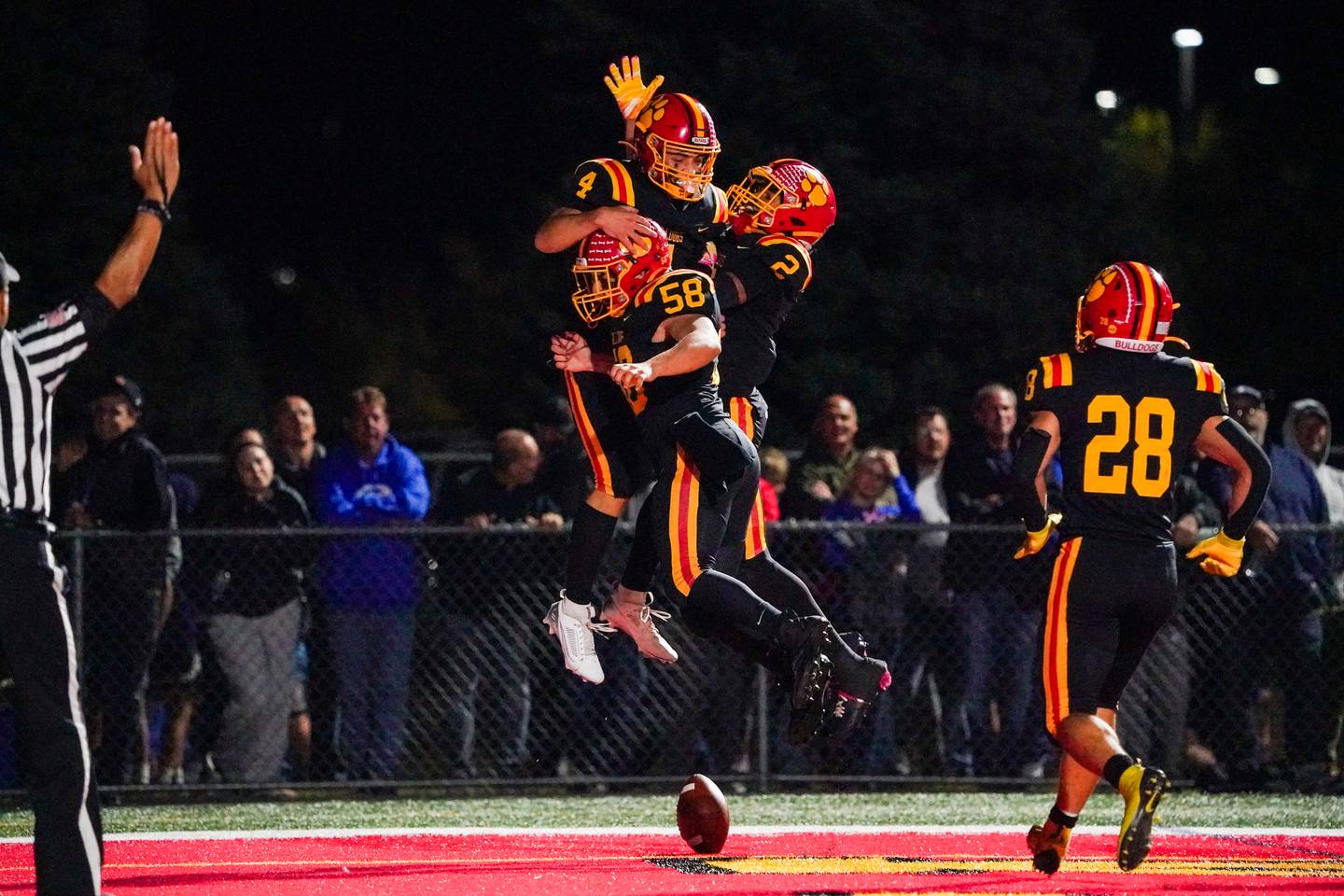 Batavia's Bodi Anderson (4) celebrates with Steven Bannos (58) and Isaiah Brown (2) after catching a pass by Brown for a touchdown against Geneva during a football game at Batavia High School on Friday, Oct. 4, 2024.