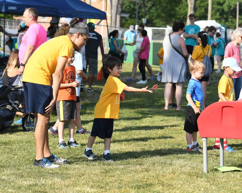 Alex Zavala, 5 years old, tosses a ring in a game while his father David Zavala looks on before the start of the Leadershop 5k run-walk held in La Grange on Friday June9, 2023.