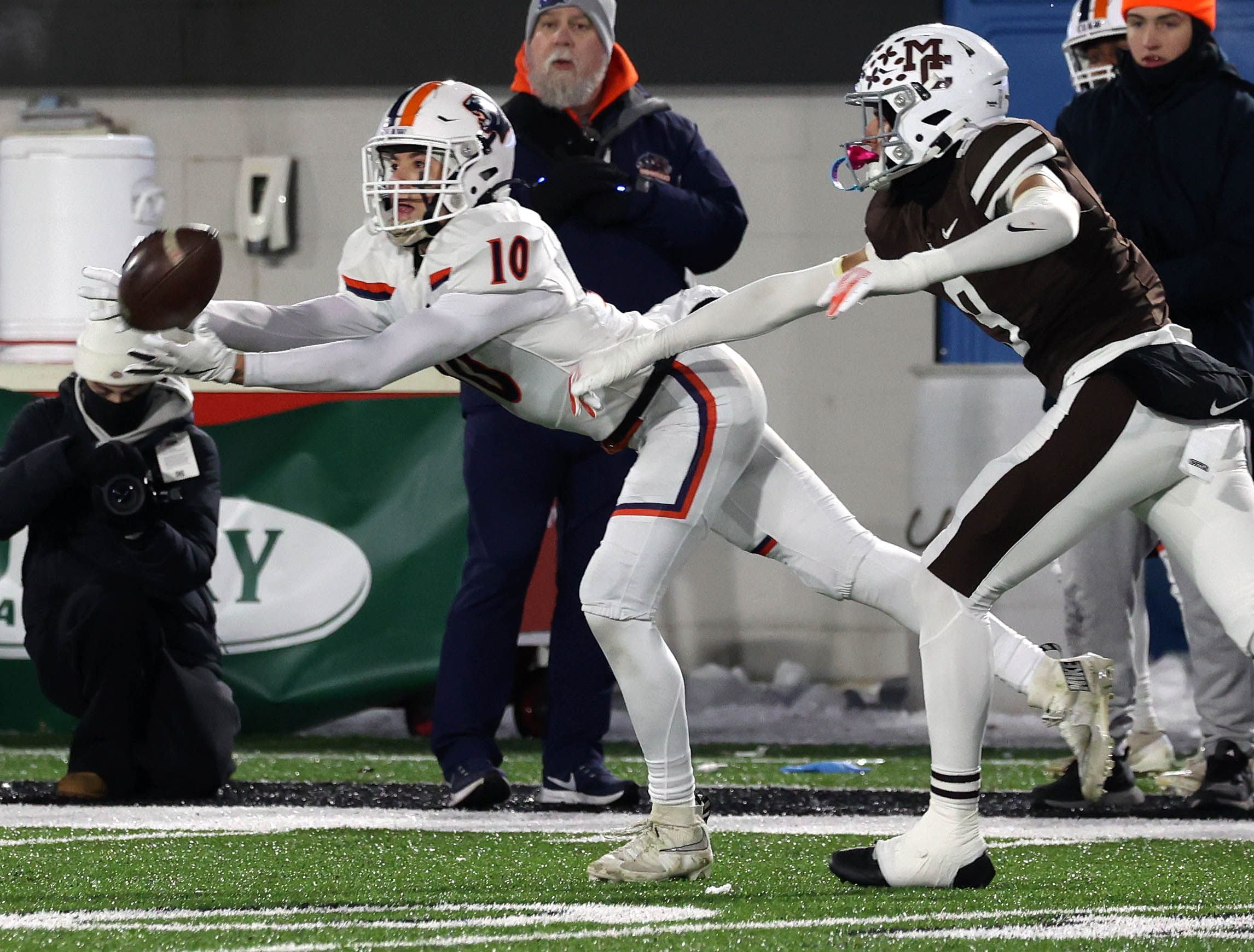 Oswego's Mariano Velasco makes a diving catch behind the coverage by Mount Carmel's Isaac Saldana Wednesday, Dec. 3, 2025, during their IHSA Class 8A state chamionship game in Huskie Stadium at Northern Illinois University in DeKalb.