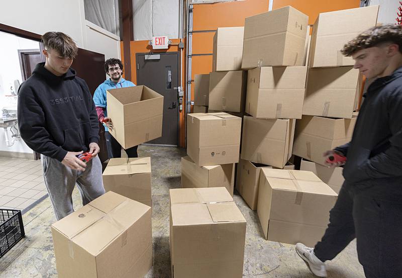 Sterling High School Impact students Reed Miller (left), Jonathan Porter and James Miller organize boxes Wednesday, Nov. 26, 2025, in Sterling. The boxes will be filled with food and given to families in need for the holiday.