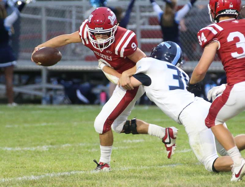 Hall quarterback Gianni Guerrini scrambles to avoid a sack from Bureau Valley's Cameron Lemons on Friday, Sept 8, 2023 at Richard Nesti Stadium.