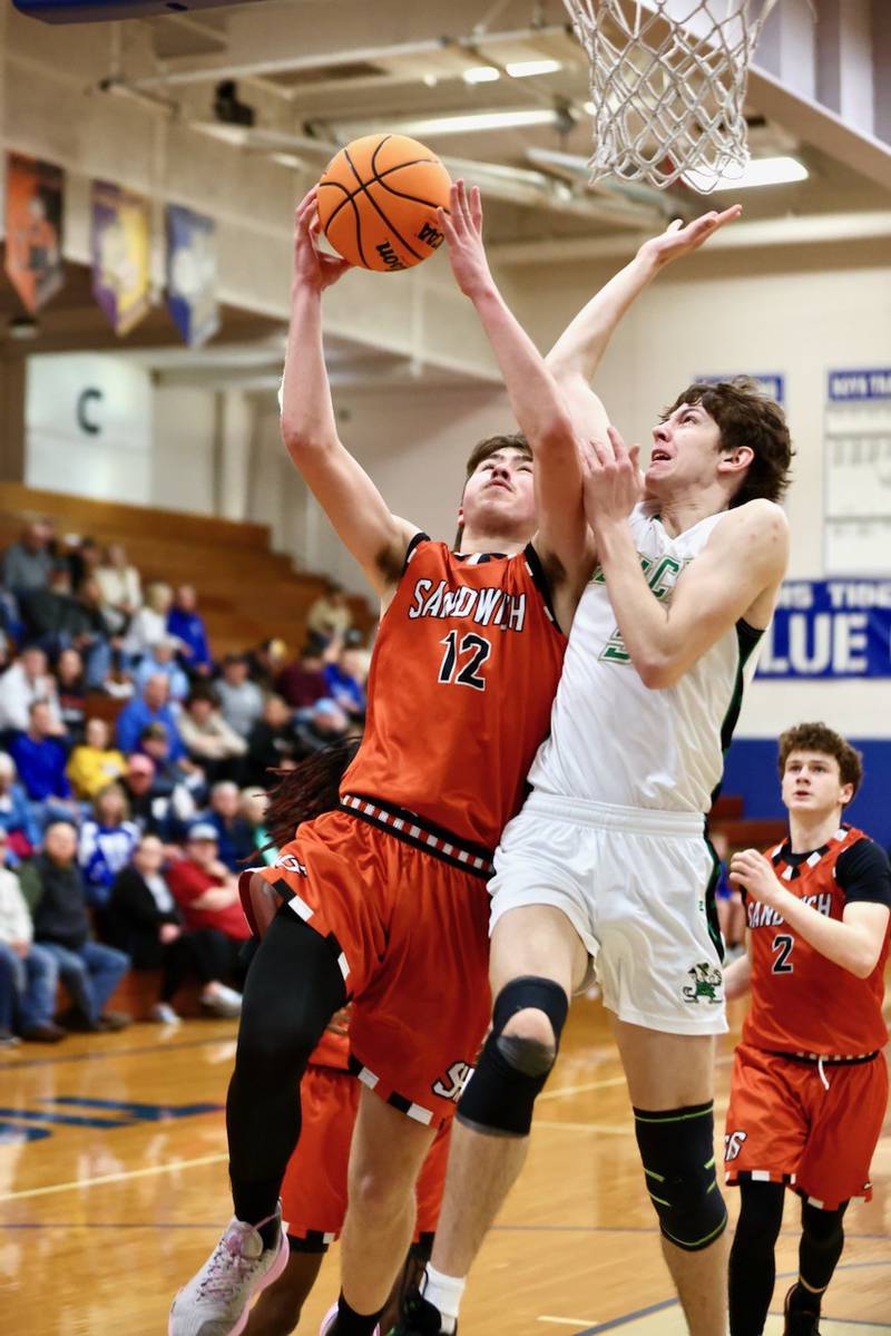 Sandwich's Braden Behringer takes in a layup over Seneca's Sebastian Deering in Wednesday's regional semifinal game at Princeton. The Irish pulled away for a 74-59 win.