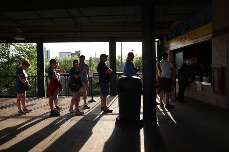 The sun sets as fans line up for Sunshine Mexican Cafe’s new food stand at DuPage Medical Group Field on the Joliet Slammers home opener. Friday, May 13, 2022, in Joliet.