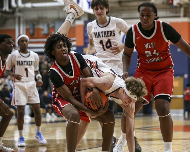 Oswego's Brayden Borrowman (30) dives for possession during their basketball game between West Aurora at Oswego Monday, Nov 24, 2025 in Oswego.