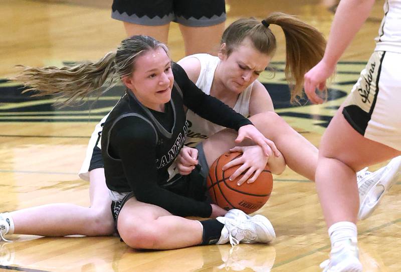 Kaneland's Kailey Plank (left) and Sycamore's Mallory Armstrong go after a loose ball during the Class 3A regional final game Friday, Feb. 17, 2023, at Sycamore High School.