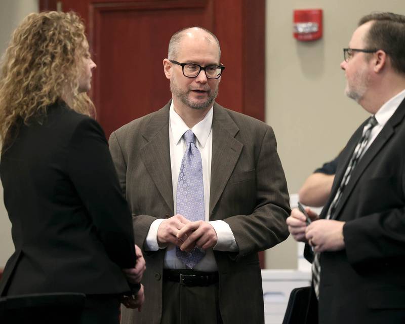 Jonathan Hurst (center) talks to his lawyers Emma Franklin and Chip Criswell Thursday, Jan. 23, 2025, during his trial at the DeKalb County Courthouse in Sycamore. Hurst is charged in the 2016 slayings of Sycamore elderly mother and son Patricia and Robert Wilson.