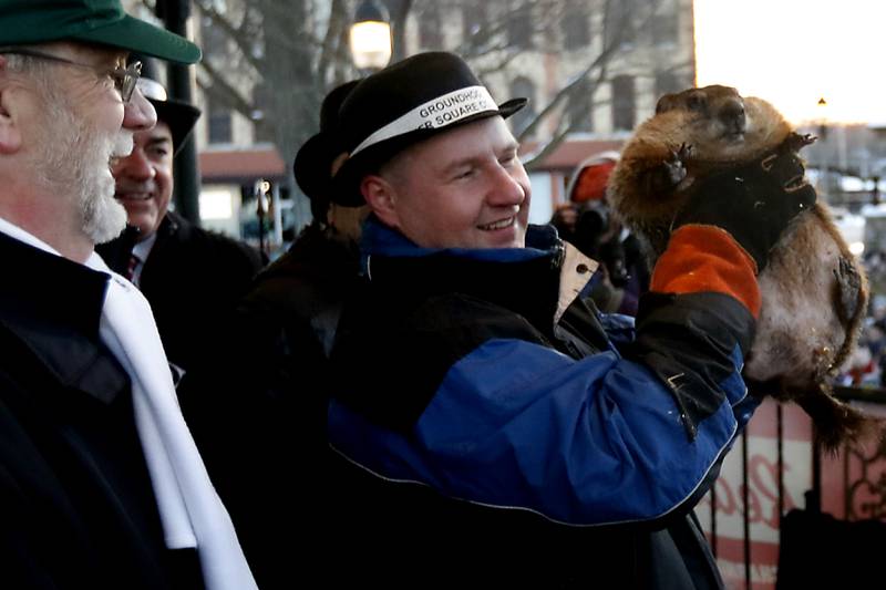 Woodstock Willie is held by handler Mark Szafran as Willie looks to see if he can see his shadow Thursday, Feb. 2, 2023, during the annual Groundhog Day Prognostication on the Woodstock Square.