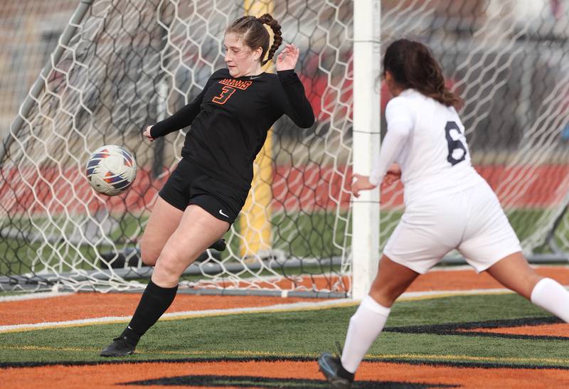 DeKalb’s Isabella Schmerbach tries to kick the ball away from her goal as Belvidere North’s Keyla Suarez charges hard during their game Wednesday, March 15, 2023, at DeKalb High School.