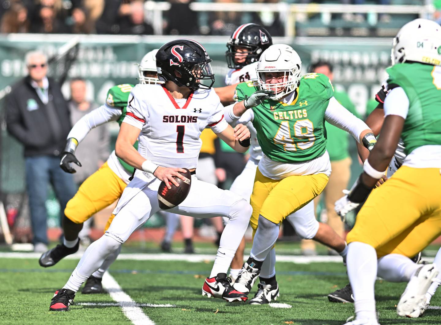 Springfield's Brody Scheffler (1) getting pressured by Providence Catholic's Dom Infelise (49) during the class 5A first round playoff game on Saturday, NOV. 01, 2025, at New Lenox.