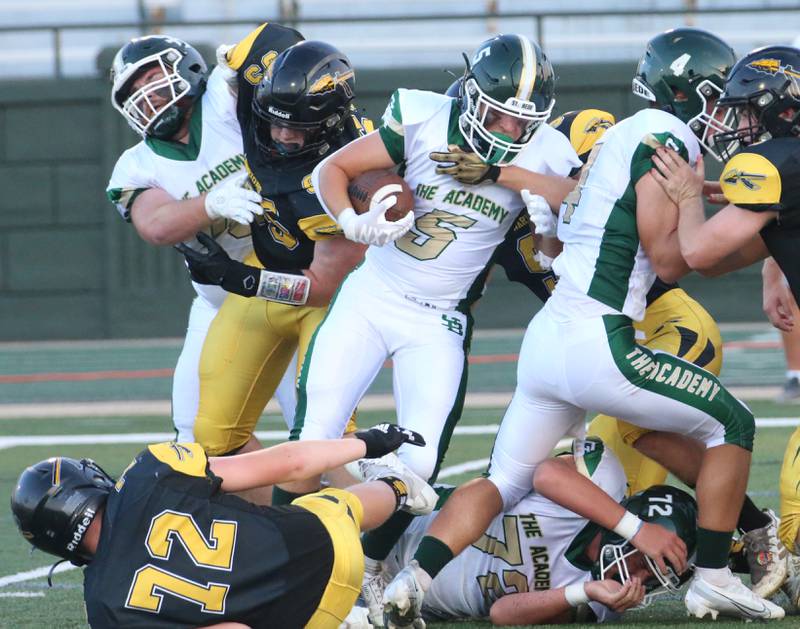 St. Bede's Halden Hueneburg (center) pushes and shoves his eay through the pile to gain a few yards against Tuscola on Friday, Aug. 25, 2023 at Tucci Stadium  in Bloomington.