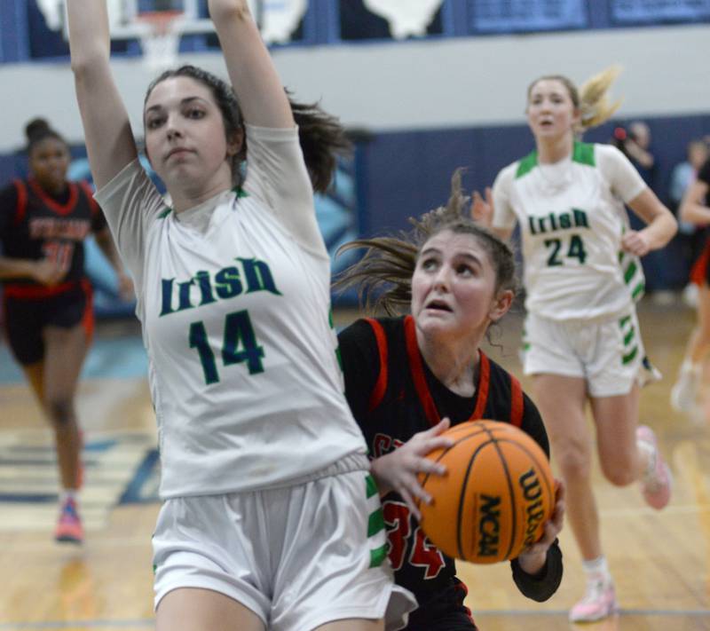Stillman Valley's Brooke Jordal (34) prepares to put up a shot as she draws contact from Peoria Notre Dame's Aiden Maloney (14) at the 2A Super-Sectional on Monday, March 3, 2025 at Bureau Valley High School in Manlius.