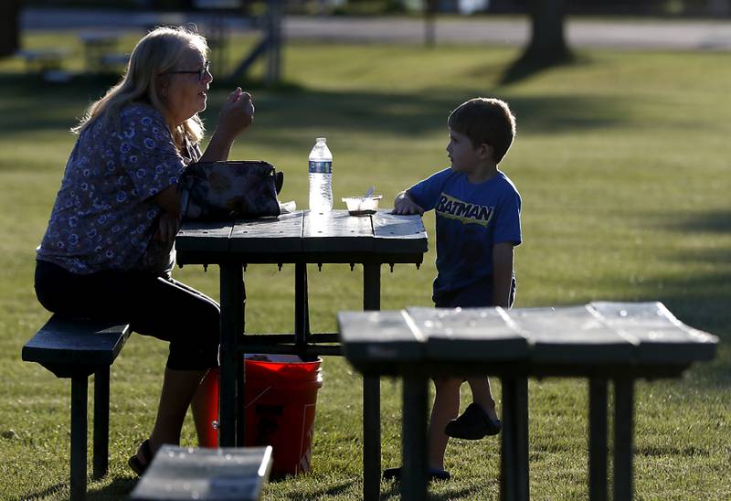 Kian Rivera, 4, of McHenry, eats ice cream with his grandmother, Colleen Maxstadt of Wonder Lake, during National Night Out! Tuesday, August 9, 2022, at Petersen Park in McHenry. The event was put on by the McHenry County Sheriff’s Office, City of McHenry Police Department and the McHenry County Conservation District and featured demonstrations, food and fun activities. National Night Out is held nationally in over 50,000 cities and is designed to help create relationships between neighbors and law enforcement community.