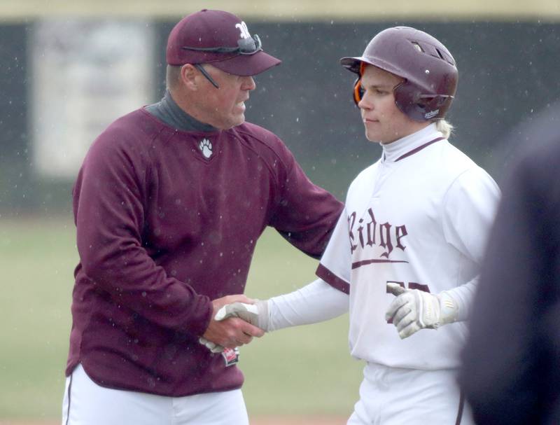Prairie Ridge’s Head Coach Glen Pecoraro greets Gabriel Porter as the Wolves face Jacobs in varsity baseball on Wednesday, April 9, 2025, at Prairie Ridge High School in Crystal Lake.