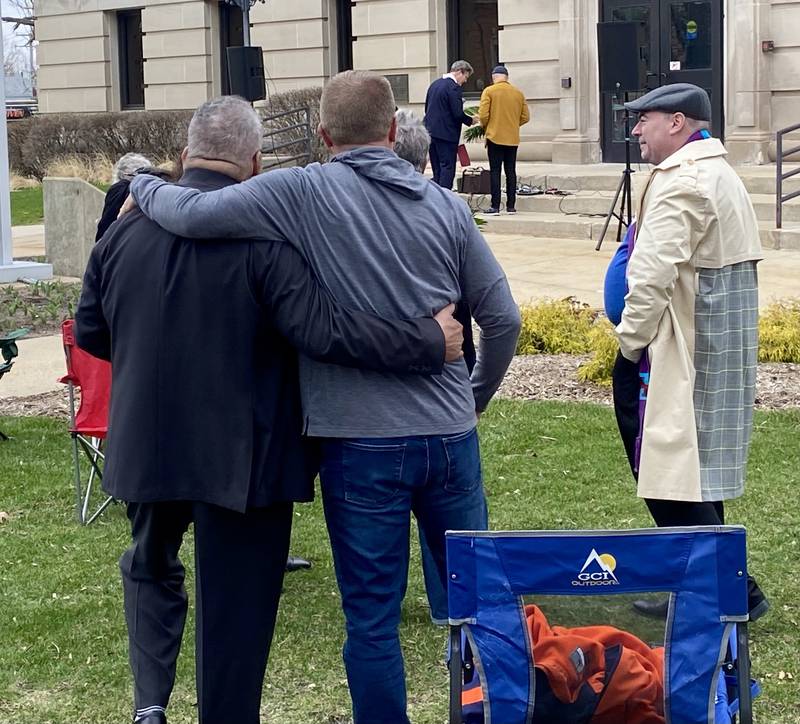 The Rev. Luis Filipe Reyes-Rosario (left) hugs a worship service goer as the benediction is read at the end of a Palm Sunday Faith Action event on Sunday, March 29, 2026, in front of the DeKalb County Courthouse in Sycamore. Reyes-Rosario and other area Christian ministers organized the event to combat the rise of Christian nationalism in the U.S.