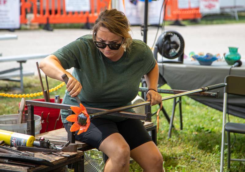 Kayla Socha of Atlanta, Ga. demonstrates the glass blowing process during the 75th anniversary of the McHenry County Fair in Woodstock on Wednesday, August 2, 2023.