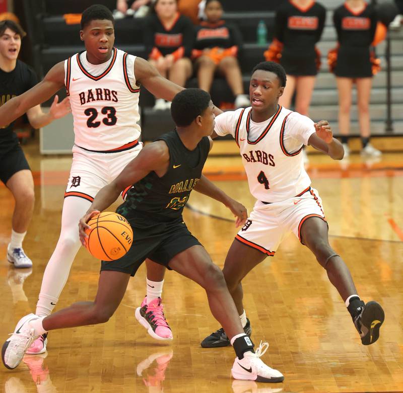 Waubonsie Valley's Tyreek Coleman is trapped by DeKalb's Davon Grant (left) and DeKalb's Marquise Bolden during their game Friday, Feb. 21, 2025, at DeKalb High School.