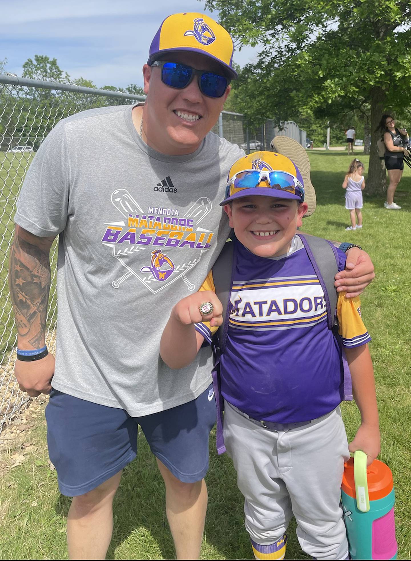 Chad Hochstatter (left) poses for a photo with his son, Paul, after a baseball tournament. Hochstatter, a Marine Corps veteran who served two tours in Iraq, is the Mendota High School resource officer and is active in several youth sports in Mendota.