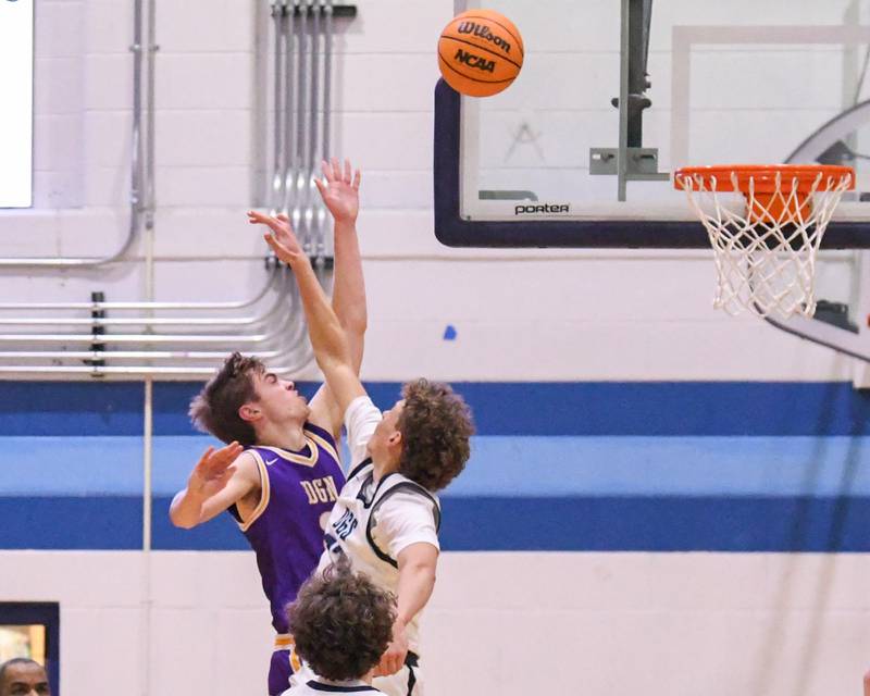 Downers Grove North's Nolan Hurter, left, takes a shot while being defended by Downers Grove South's Joe Grippo, during the game on Saturday Dec. 21, 2024, held at Downers Grove South High School.