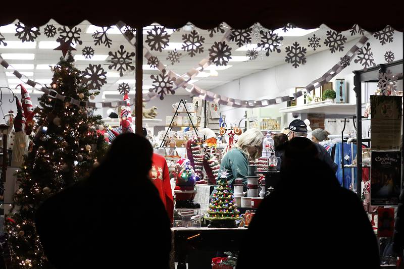 People window shop during the Lighting of the Square Friday, Nov. 25, 2022, in Woodstock. The annual event featured brass music, caroling, free doughnuts and cider, food trucks, festive selfie stations and shopping.