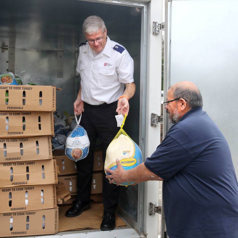 Walt Staats, (right) assistant food pantry coordinator hands turkeys to Jim Spencer, corps officer and administrator for the DeKalb Salvation Army, Friday, Nov. 22, 2024, during the Let’s Talk Turkey food drive at their facility in DeKalb. The campaign, in association with WLBK, accepted turkeys, hams and monetary donations for Thanksgiving meals.