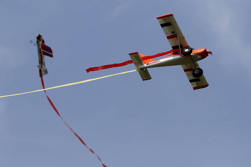 Two radio-controlled planes have a streamer dogfight on Thursday, Aug. 8, 2024, near Hebron.